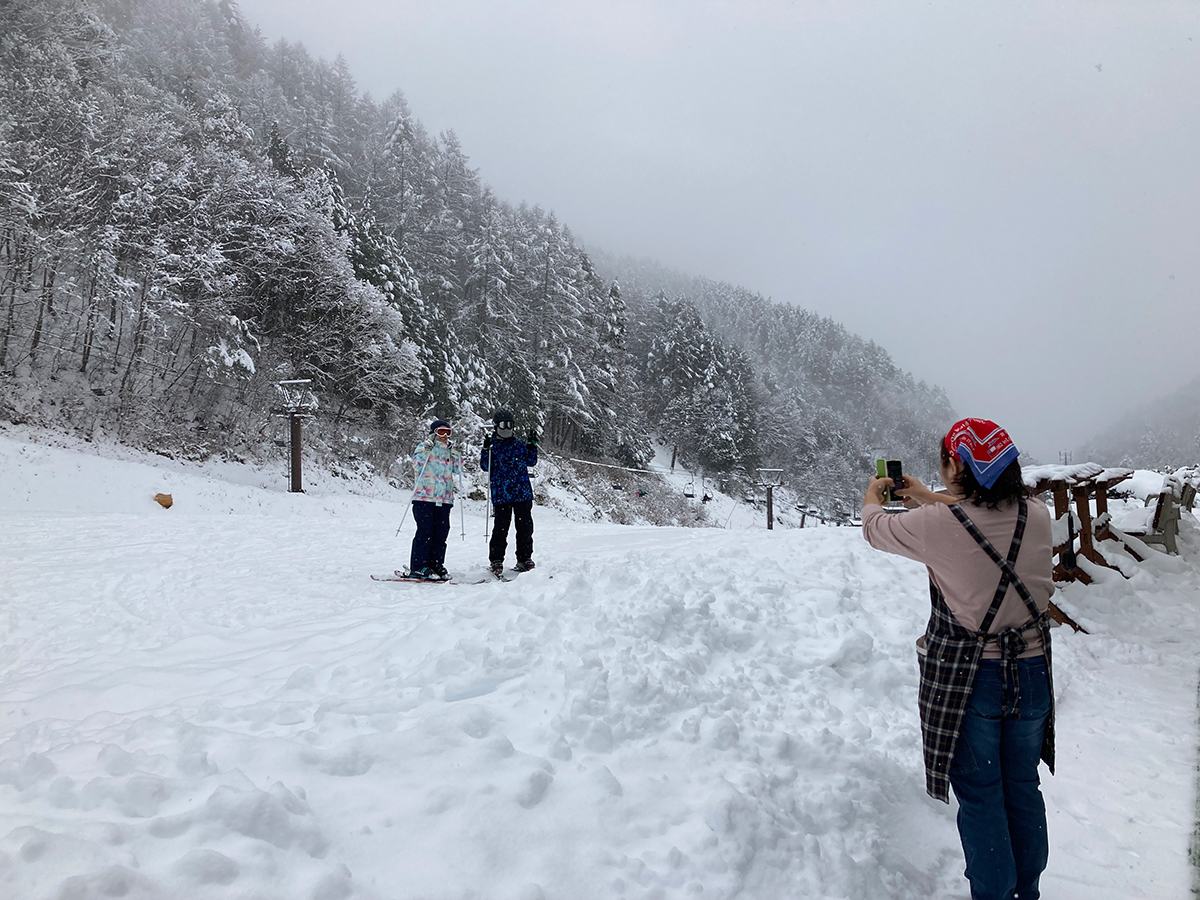 雪化粧した木々に囲まれたゲレンデで記念撮影